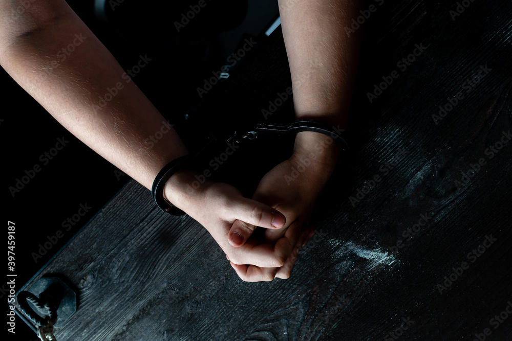hands in handcuff on table