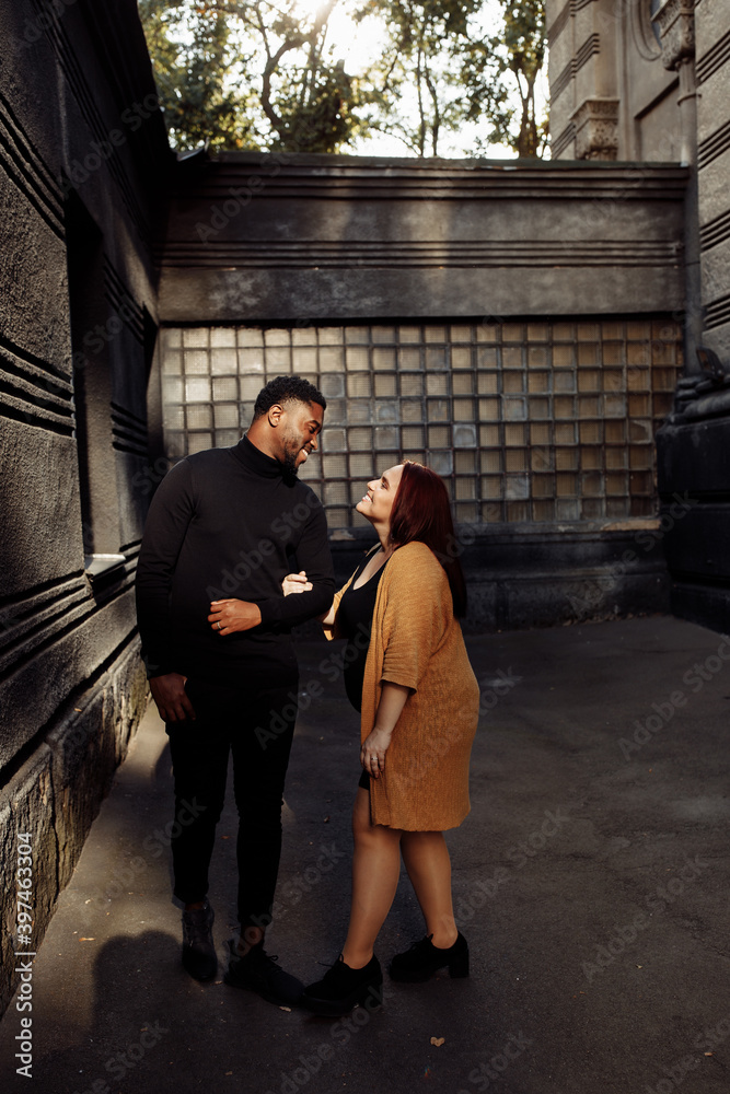 Fashion couple walking at the city, charming African American husband gently holding hands adorable white wife, happy family spend time together, street photoshoot concept