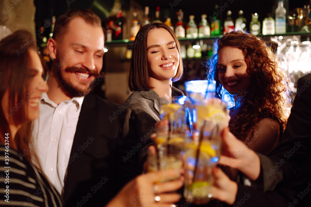 Group of friends cheering and drinking cocktails together at the bar. Young people celebrating winter holiday together with coctails at a nightclub party. Youth, lifestyle, drink, birthday concept.
Group of friends cheering and drinking cocktails together at the bar. Young people celebrating winter holiday together with coctails at a nightclub party. Youth, lifestyle, drink, birthday concept.