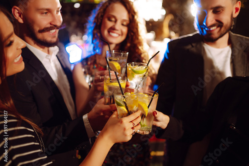 Photography Group of friends cheering and drinking cocktails together at the bar