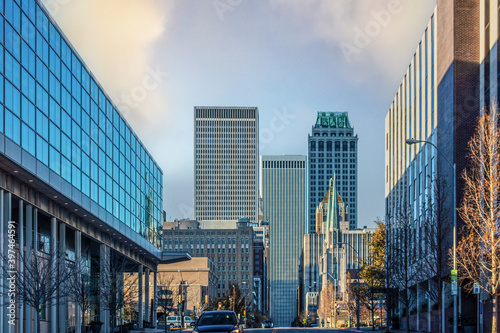 Streets of Tulsa with strange lights casting colored shadows on both sides of street leading to tall skyscrapers at the end - winter scene