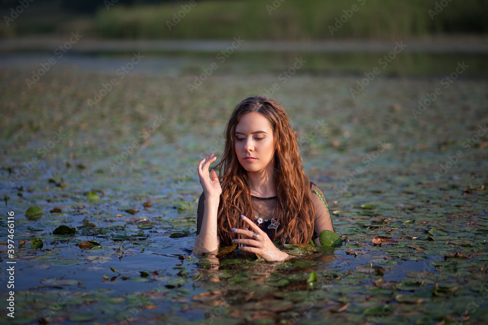 Fototapeta premium beautiful girl bathes in a swamp, a mermaid in a swamp.
