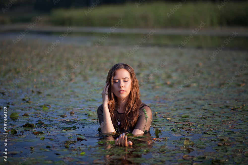 Fototapeta premium beautiful girl bathes in a swamp, a mermaid in a swamp.