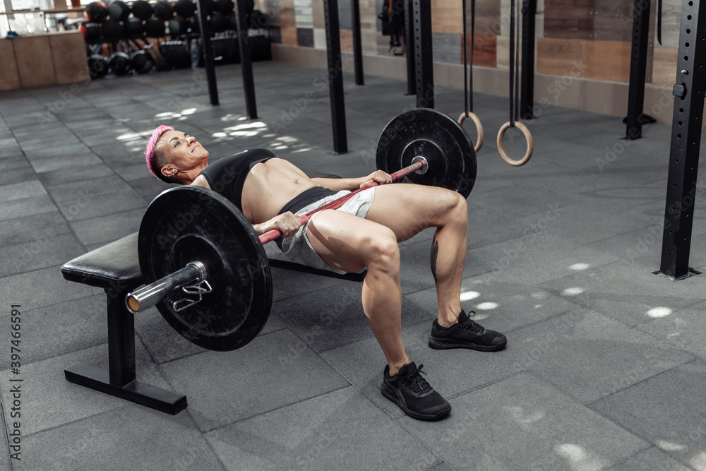 Young athletic strong woman practicing glute bridge exercise with