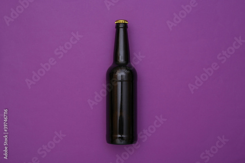 Bottles of dark beer on purple background. Top view