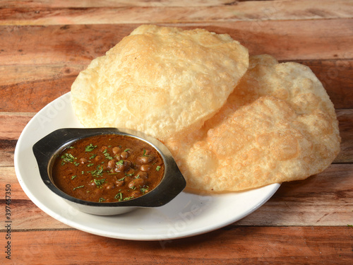 Peshwari Chole Bhature, spicy Chick Peas curry also known as Chole or Channa Masala usually served with fried puri or Bhature, selective focus photo