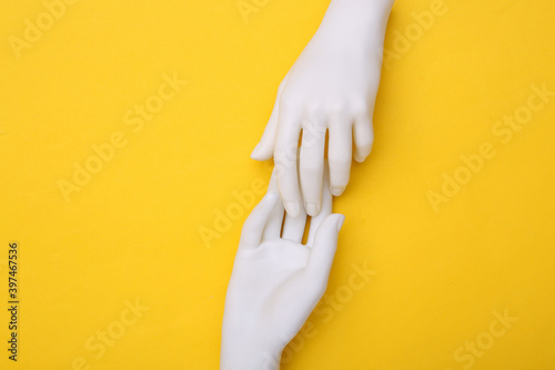 The mannequin's white hands touch each other on yellow background. Minimalism. Concept art