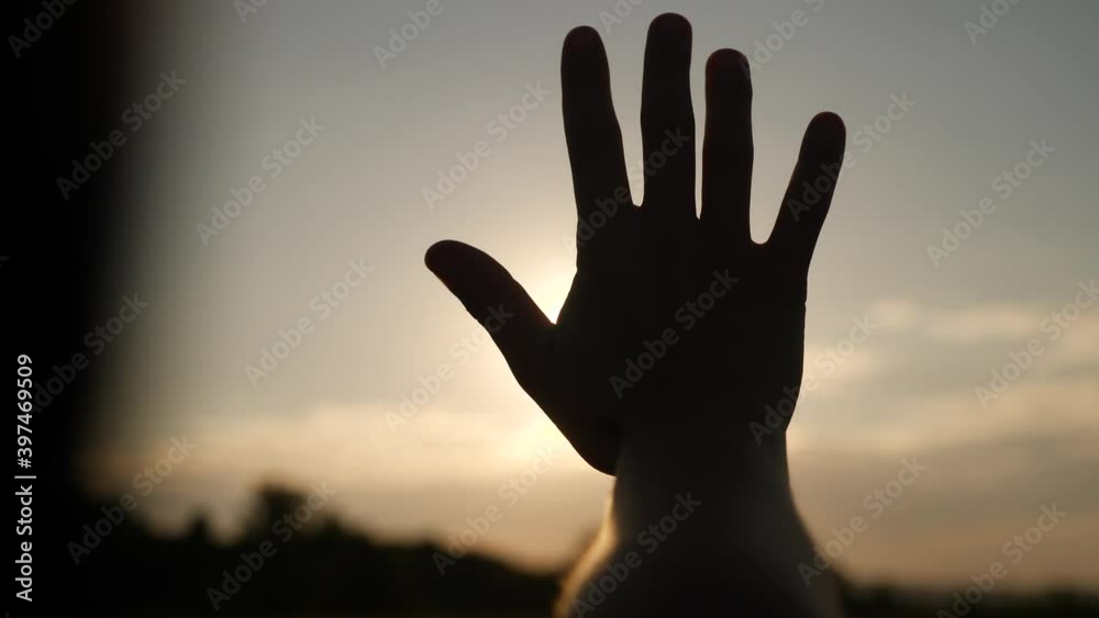 girl stretches out her hand in the sun. faith in god dream a religion concept. hand in the sun close-up silhouette dream sunlight of happiness girl stretches out her hand in the sun. faith in god dream a religion concept. hand in the sun close-up silhouette dream sunlight of happiness