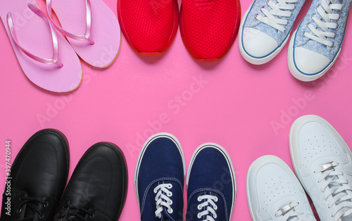 Lot of pairs of shoes on pink background. Minimalistic fashion concept. Top view. Copy space