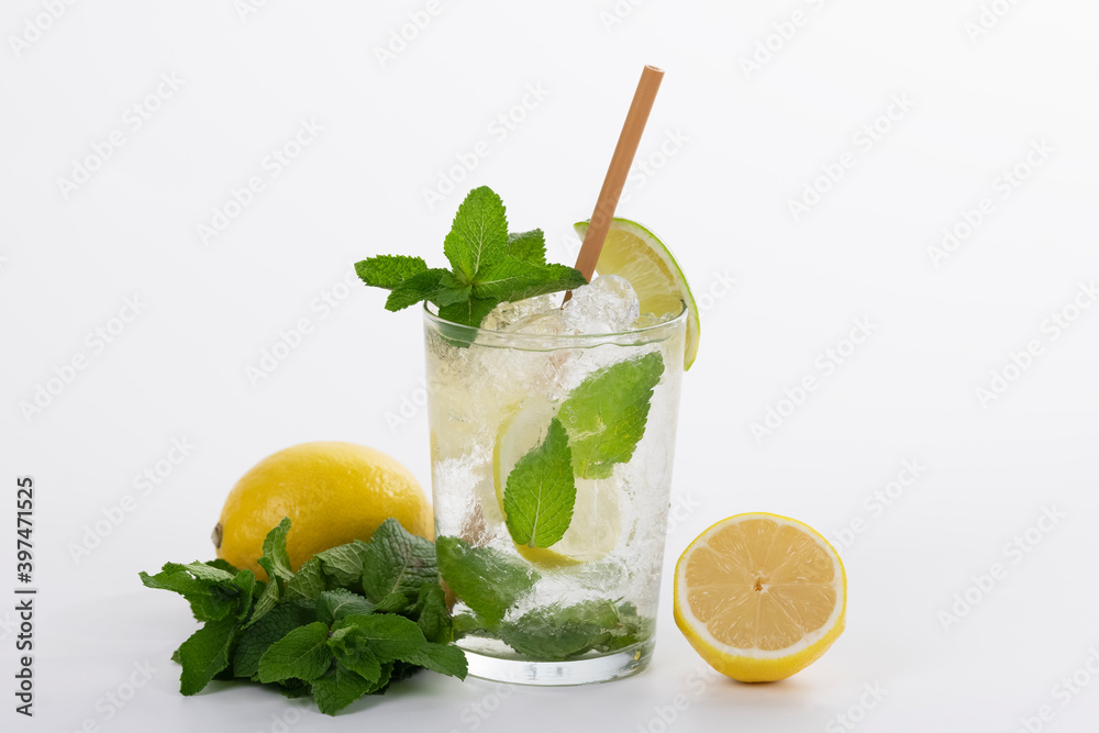 Fototapeta premium a refreshing mojito cocktail with a straw surrounded by lemons and fresh mint leaves