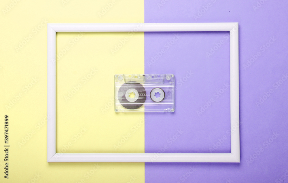 Audio cassette on yellow purple pastel background with white frame. Studio shot. Creative retro flat lay. Top view. Minimalism. 80s Audio cassette on yellow purple pastel background with white frame. Studio shot. Creative retro flat lay. Top view. Minimalism. 80s