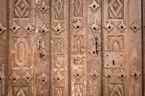 old brown wooden door with metallic ornaments 