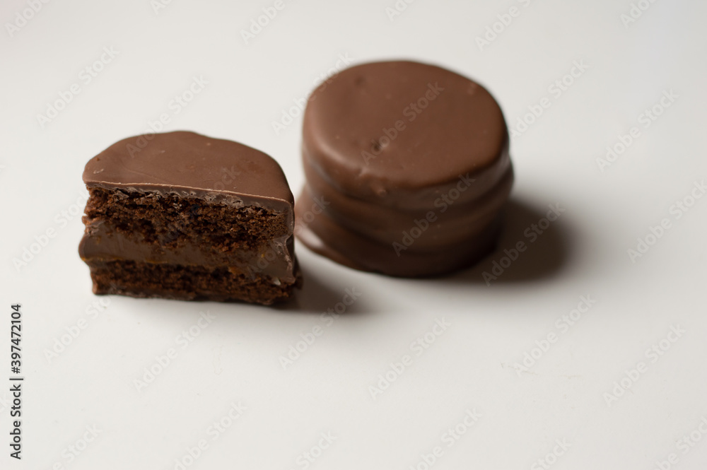 Uruguayan and Argentinian alfajor in dark scenery. Typical South American food. Chocolate cake with dulce de leche filling. Uruguay. Argentina Uruguayan and Argentinian alfajor in dark scenery. Typical South American food. Chocolate cake with dulce de leche filling. Uruguay. Argentina