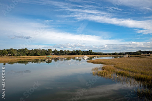 View of Shem Creek with marshland on both sides and reflections of the sky in the water.