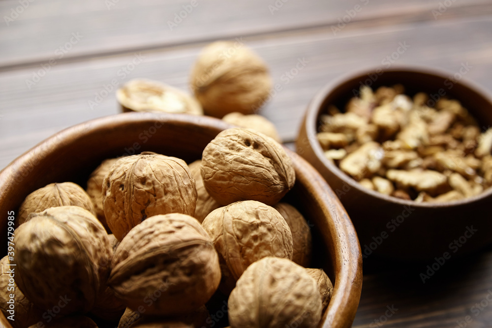 Walnut half and seeds and bowl on wooden table Walnut half and seeds and bowl on wooden table