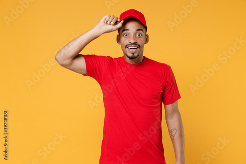 Delivery employee african man 20s in red cap blank print t-shirt uniform workwear work courier dealer service during quarantine coronavirus covid-19 virus concept isolated on yellow background studio.