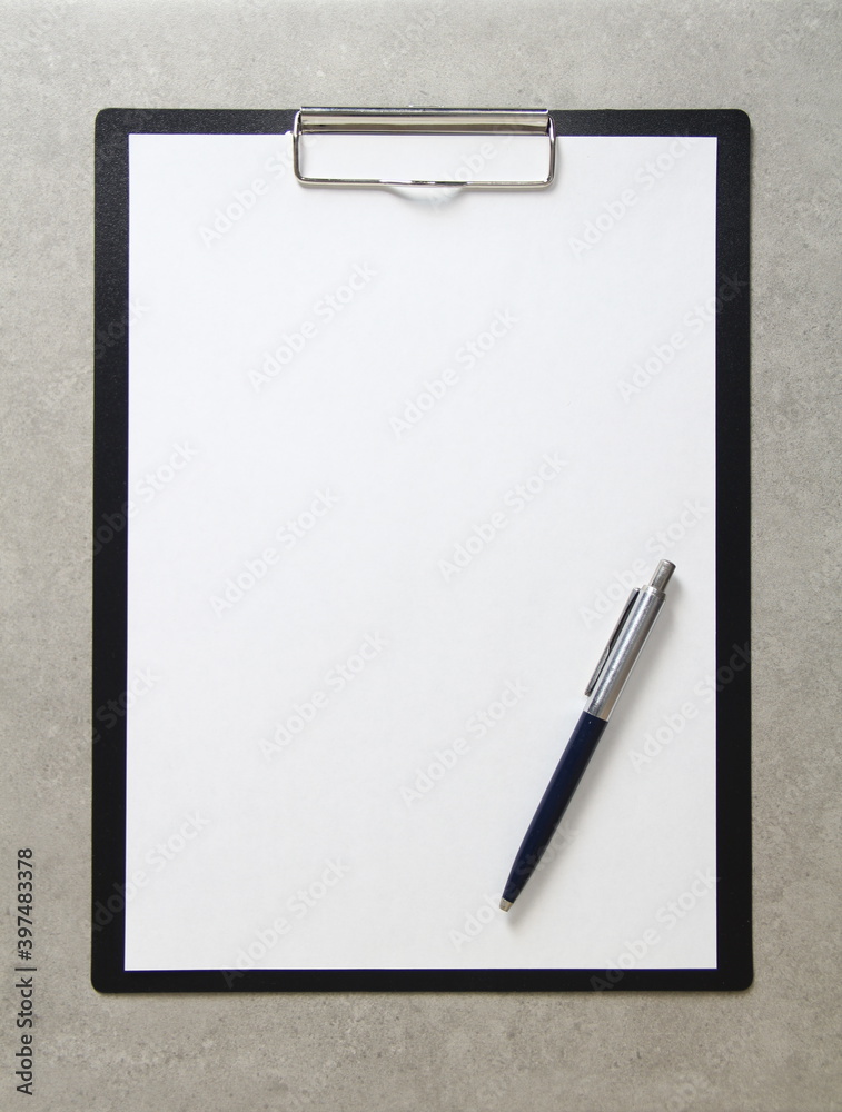 Template of white paper with a ballpoint pen on light grey concrete background in a black tablet with a clip. Concept of new idea, business plan and strategy, with empty space for text Template of white paper with a ballpoint pen on light grey concrete background in a black tablet with a clip. Concept of new idea, business plan and strategy, with empty space for text
