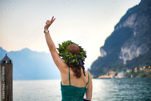 Laurea magistrale con ragazza sul lago e corona di alloro e lode photo