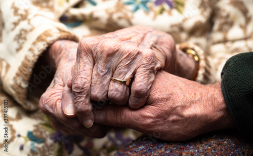 An isolated 95 year old caucasian female suffering from dementia welcomes the healing warmth of her son's hand reinforcing the power of touch in awakening communication.. 