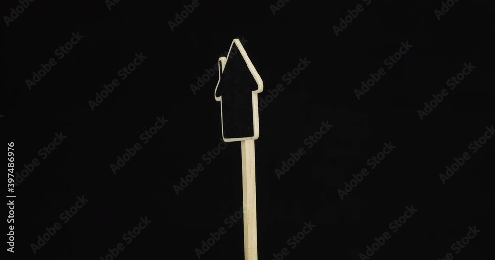 Rotation of the house-shaped sign. Wooden post with copy space in a frame on black background. Isolated Rotation of the house-shaped sign. Wooden post with copy space in a frame on black background. Isolated