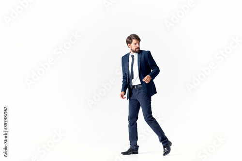 business man in a suit and shoes walks to the side on a light background Copy Space