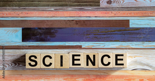 The word SCIENCE is written on wooden blocks and a colored background