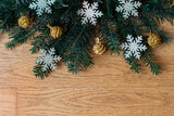 Christmas background with branches of spruce, golden baubles and shiny snowflakes.