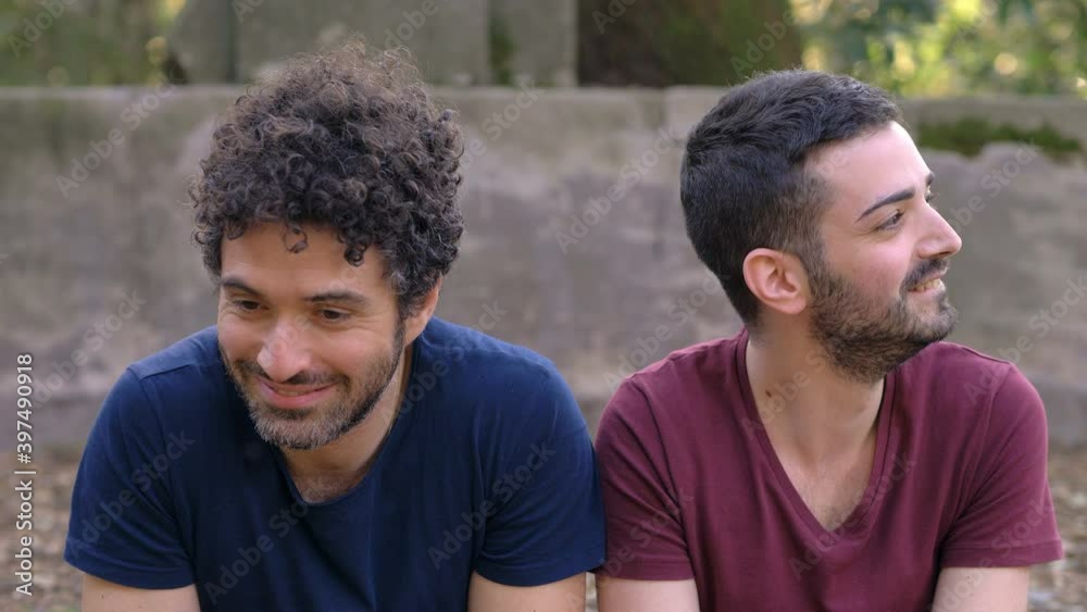 homosexuality, shyness - two embarrassed young gays kiss in the park