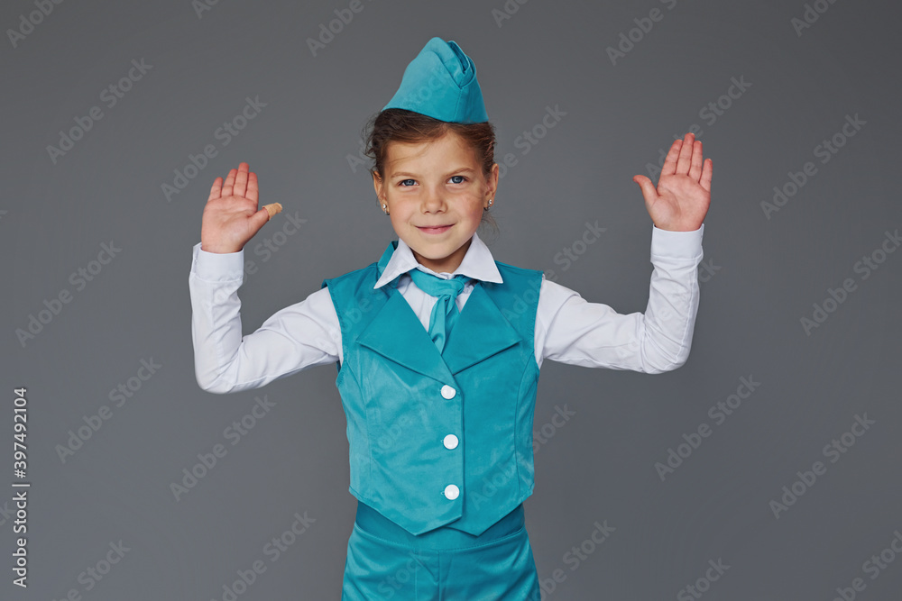 Cute little girl in blue stewardess uniform is posing for the camera Cute little girl in blue stewardess uniform is posing for the camera
