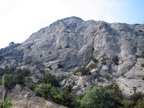 The slopes of stony mountains with sparse shrubs are dark green.