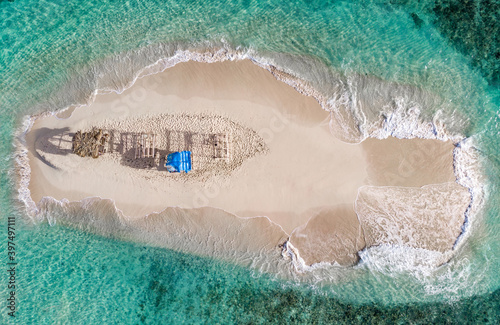 Aerial drone top down view of lone sand island with poor handmade gazebos and blue water lagoon of Atlantic Ocean, Cayo Arena, Punta Rucia, Dominican Republic 