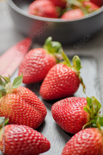 Fresh, clean strawberries ready to be sliced with a red knife.