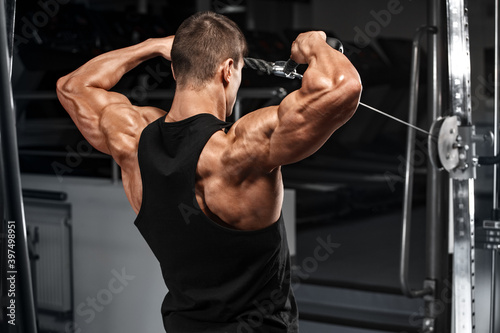Canvastavla Muscular man working out in gym doing exercise for deltoid, strong male