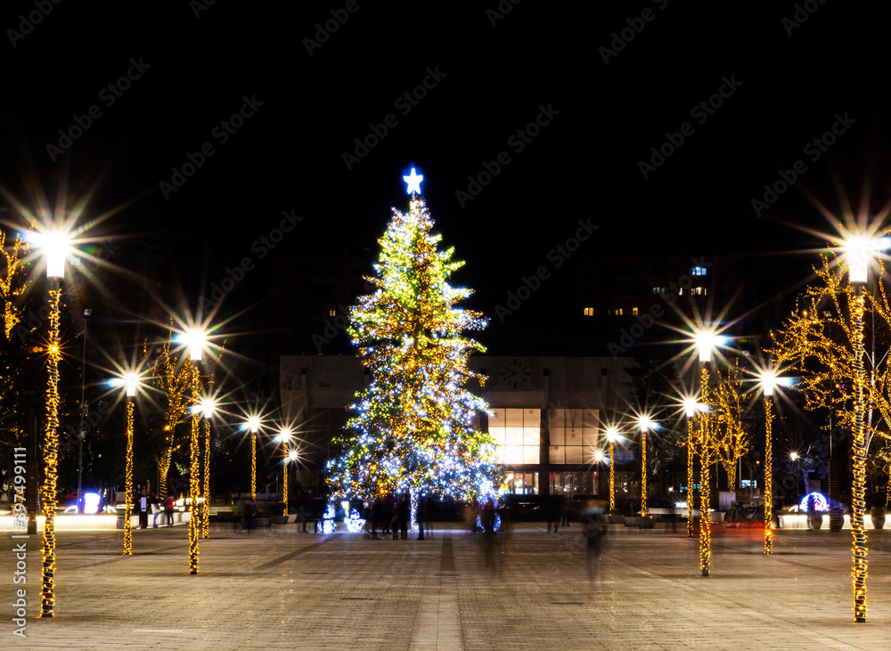 Christmas tree adorned with lights, surrounded by pillars with star shaped bulbs
