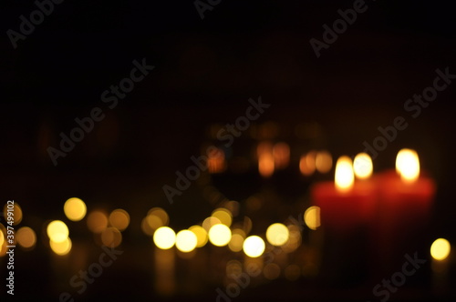 Burning candles in the dark. On a black background. Christmas. Memory. Defocused background. © amdre100