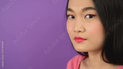close-up three quarter portrait of young asian woman on isolated purple background 4K