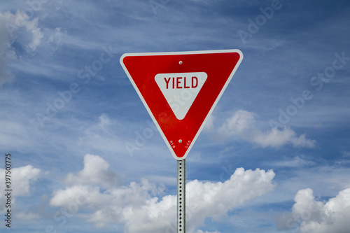 Yield sign on blue sky background (North American road sign)