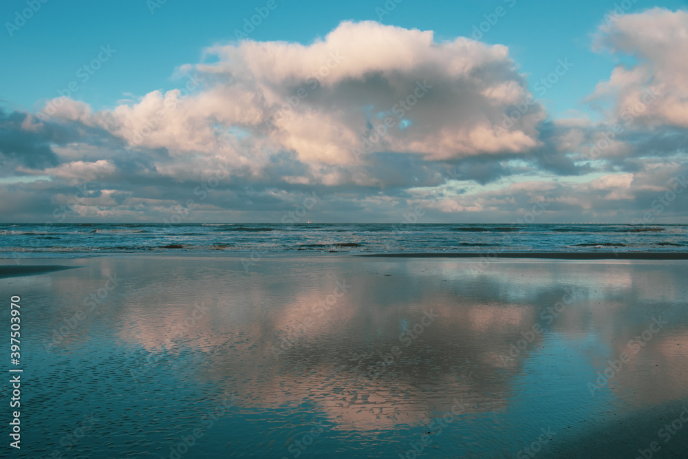 Wolken spiegeln sich im Wasser am holländischen Strand 