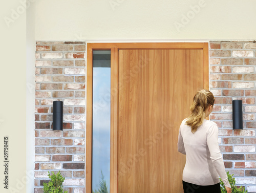 Beautiful woman opening the door of her home.Inviting the guests