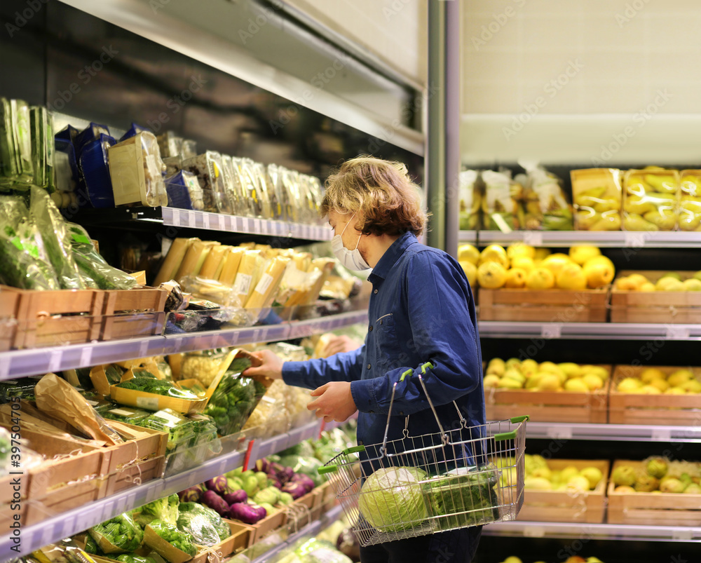 Supermarket shopping, face mask and gloves,man buying vegetables at the market.