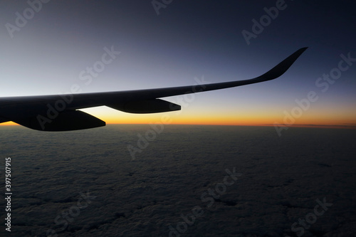 Airplane window view during a beautiful sunset above the clouds during a flight from Istanbul, Turkey to Mexico City.