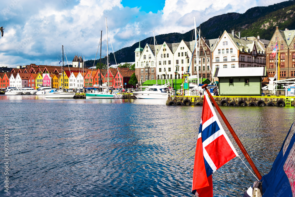 Φωτογραφία Norwegian flag on the background of the bay and the old wooden houses on the waterfront of Bergen