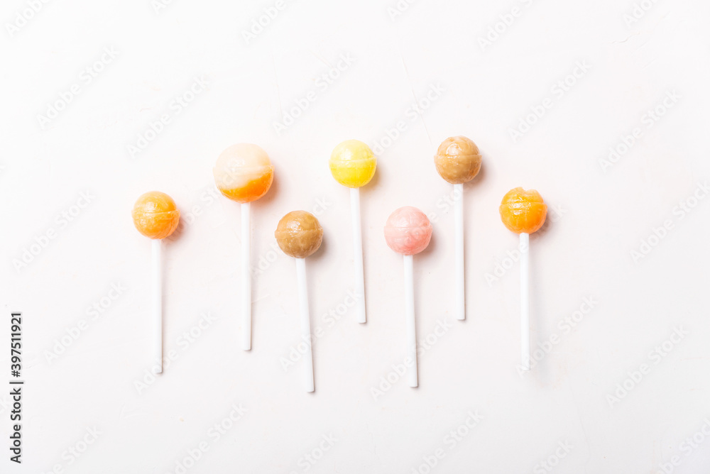 Photo of colorful lollypops on white table.