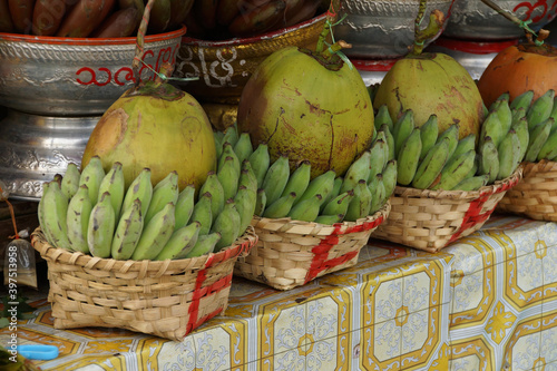 Baskets of green bananas and coconuts photo