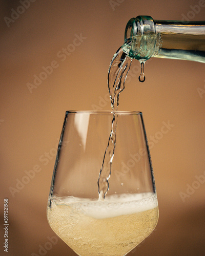 Fotografie Pooring lambrusco white wine in glass