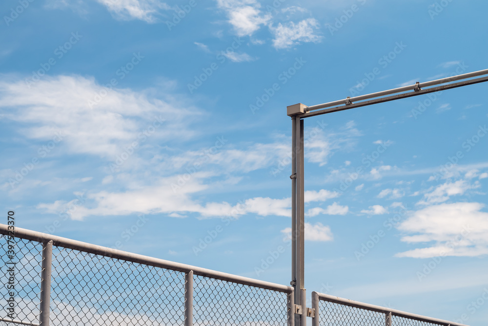 Electrical junction box with conduit pipe connection outside the building and chain Link fence against blue sky background. Electrical junction box with conduit pipe connection outside the building and chain Link fence against blue sky background.