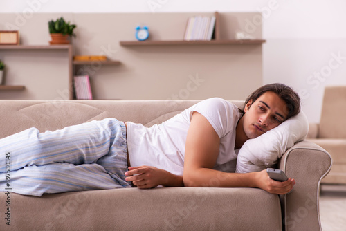 Young lazy man in oversleeping concept at home © Elnur
