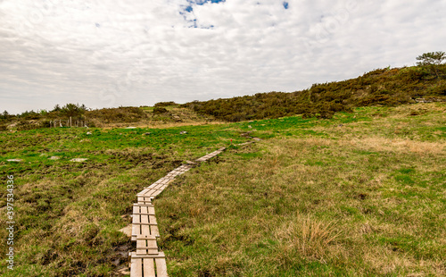 Obraz na płótnie A narrow wooden boardwalk through wet soil on a hiking track to Mastravarden at Mosteroy island, Rennesoy commune, Stavanger, Norway, May 2018 w salonie