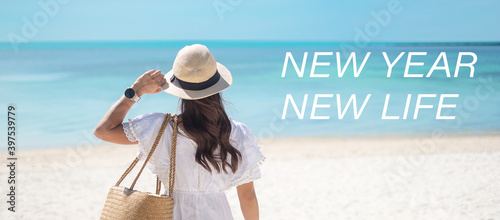 New year New life with Happy traveler woman in white dress and hat enjoy beautiful sea view and tropical beach. Freedom, relaxing, resolution and New you concept