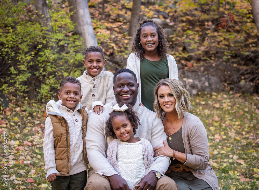 Posed Mixed Race family portrait outdoors with autumn colors